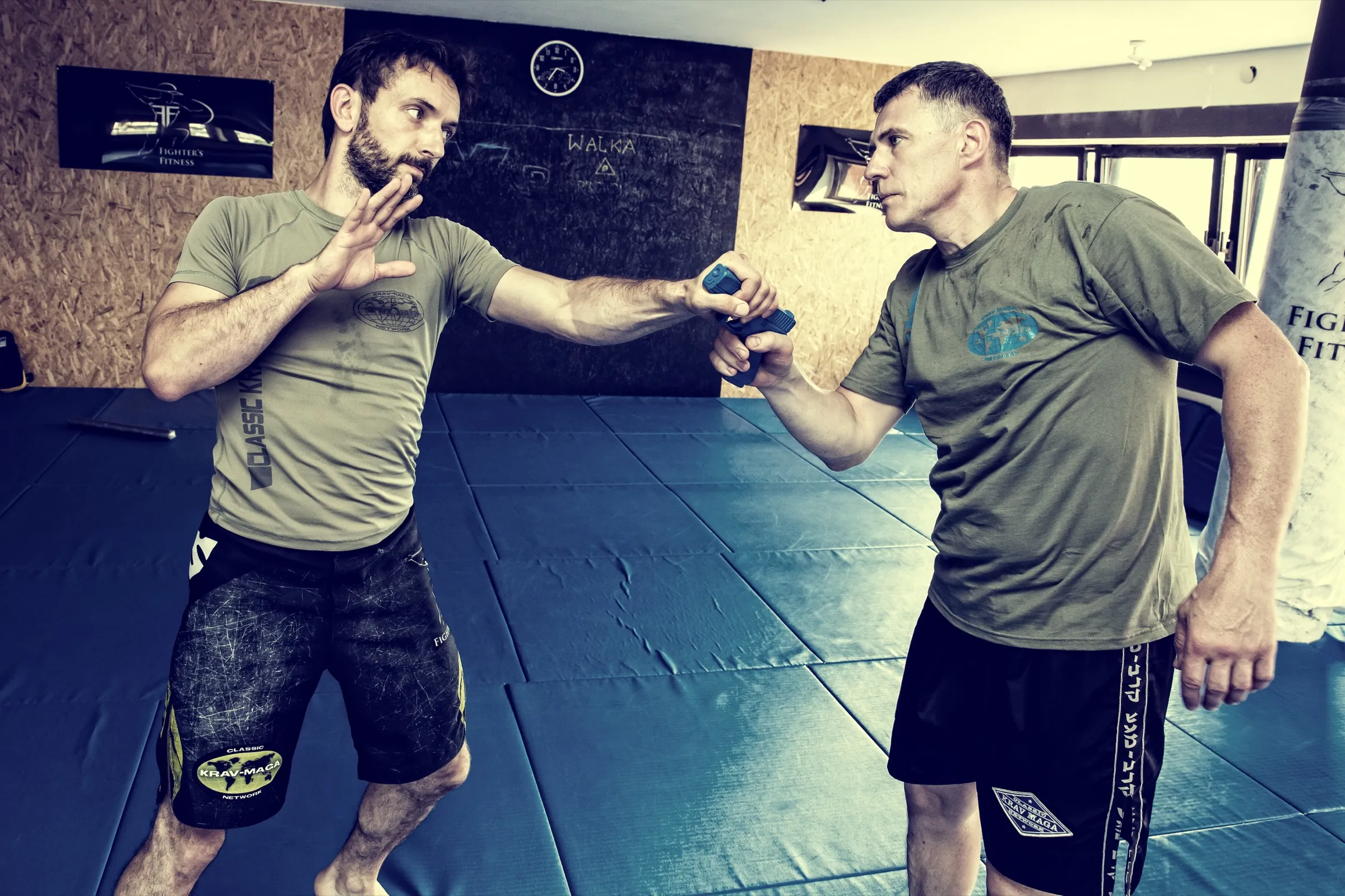 Two practitioners drilling a weapon disarm under control