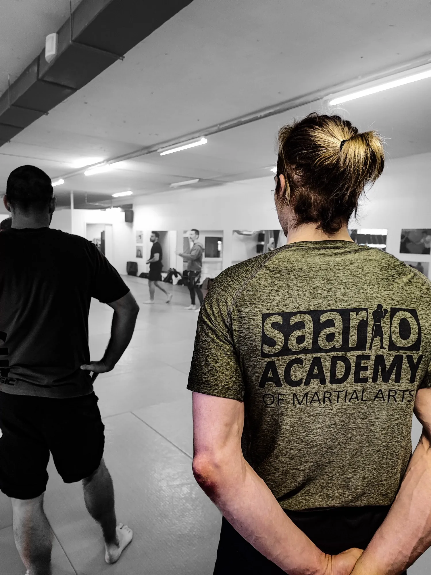 The Saario Academy crest across the back of a training shirt, the class training beyond